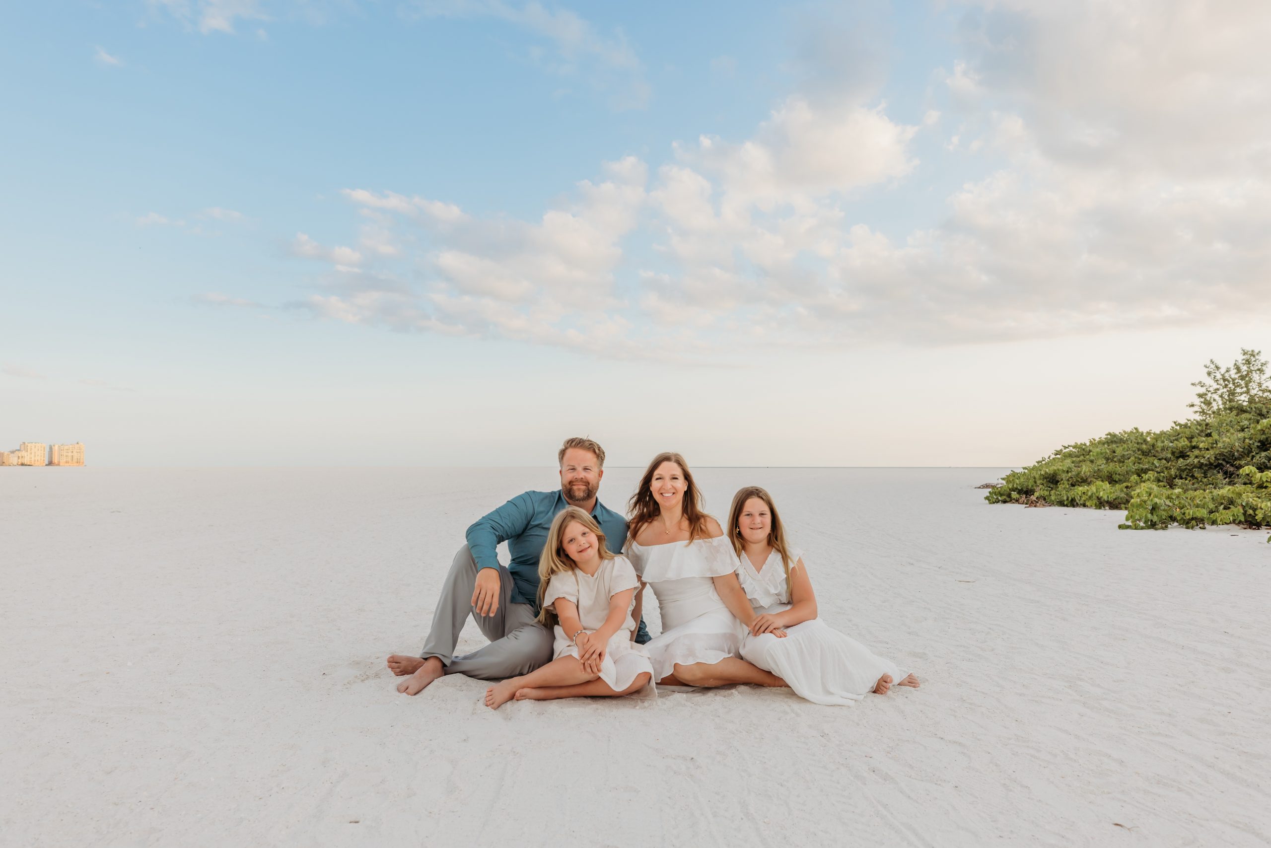 Family of four on the white sand of Marco Island at sunset